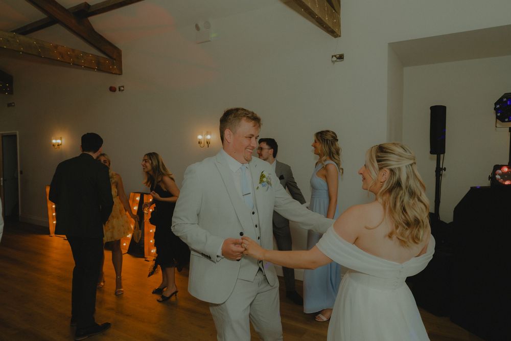 Bride and groom share a romantic first dance at their wedding reception in an elegant venue.