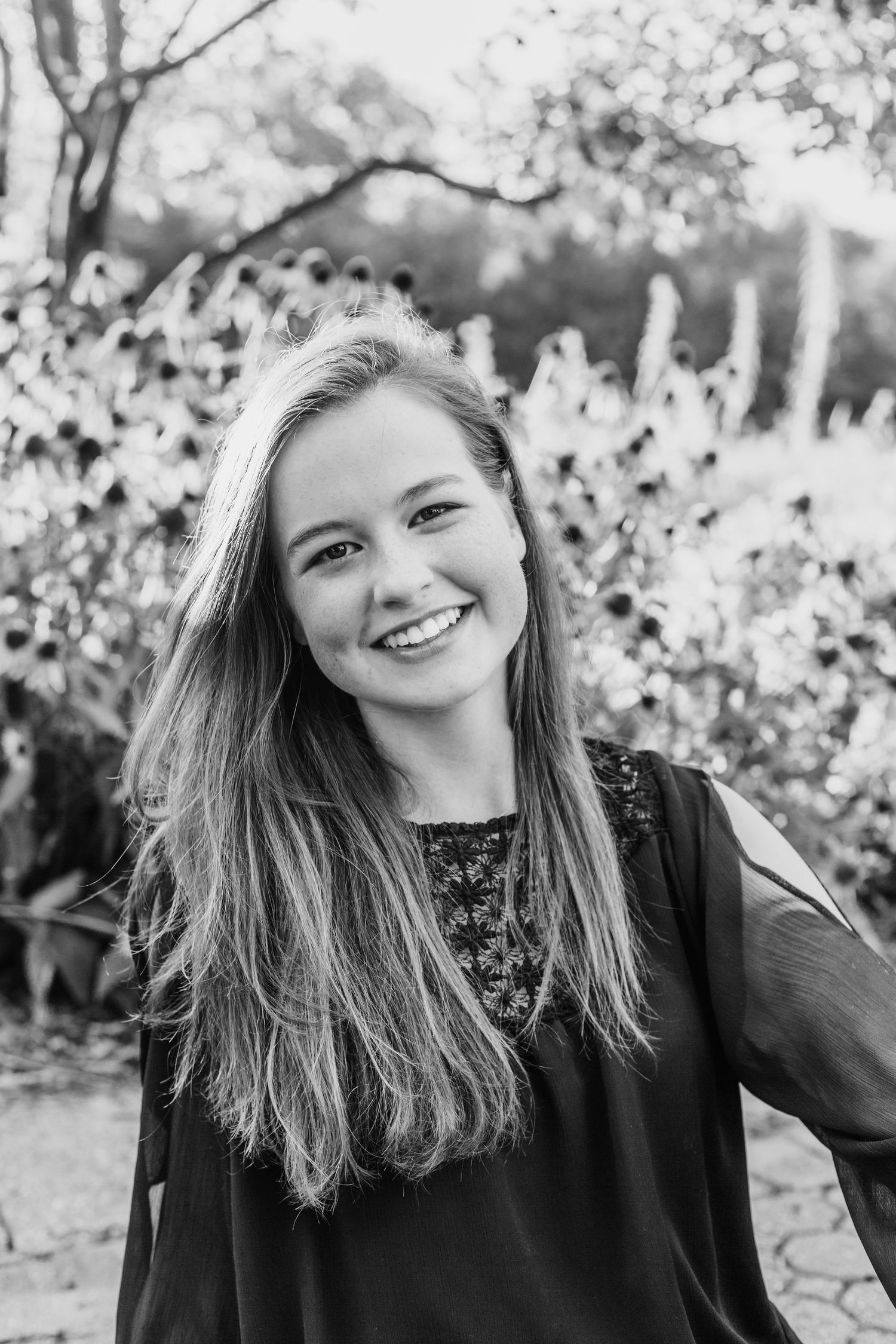 A black and white portrait captures joyful expressions against a blurred natural background.