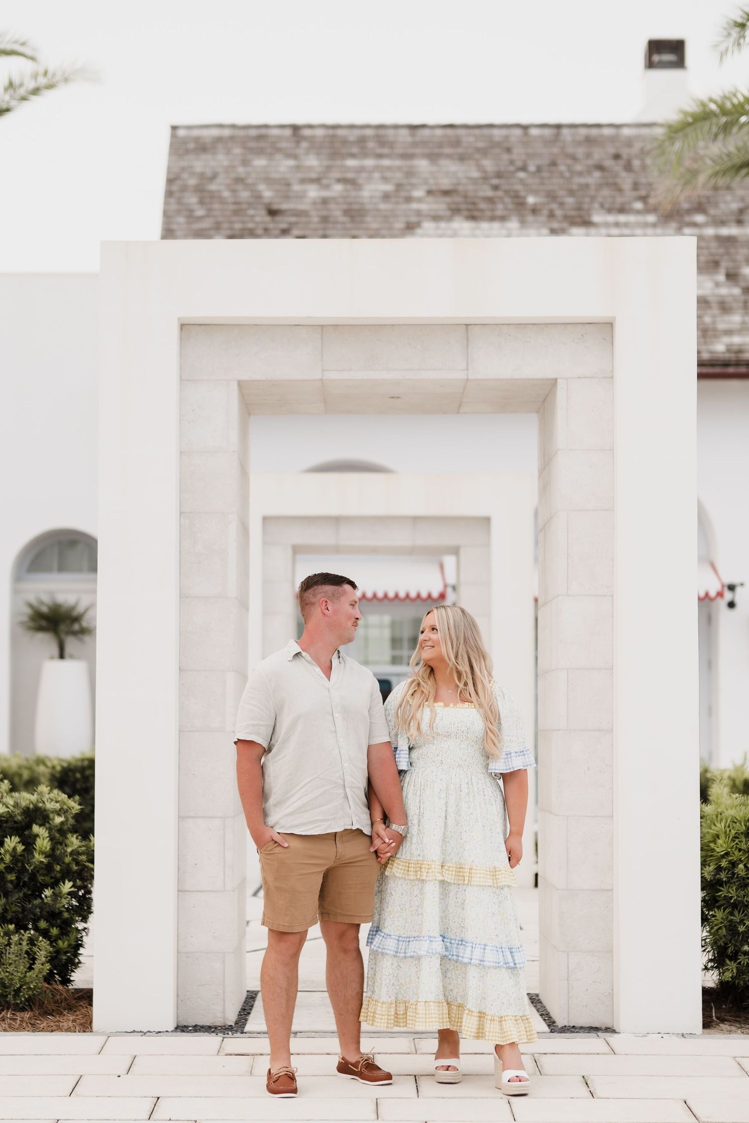Couple posing together in front of white architectural columns and doorways.