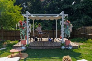 Wide shot of a decorated outdoor event space with white tents and decorations.