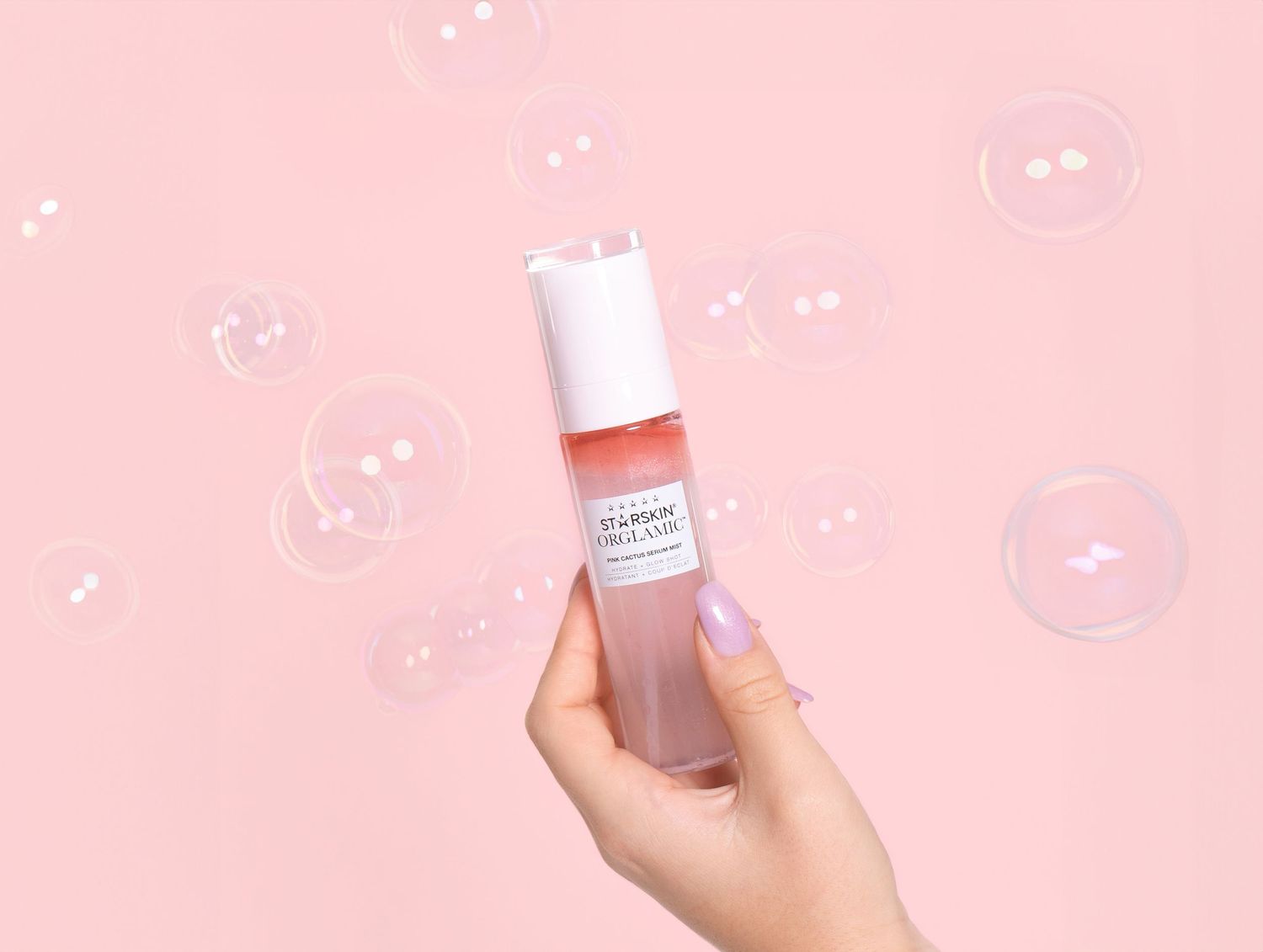 studio foto van handmodel die beauty product vasthoudt met zeepbellen op de achtergrond