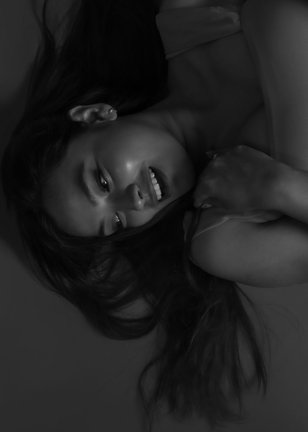 Dramatic black and white close-up portrait with expressive lighting and natural pose.