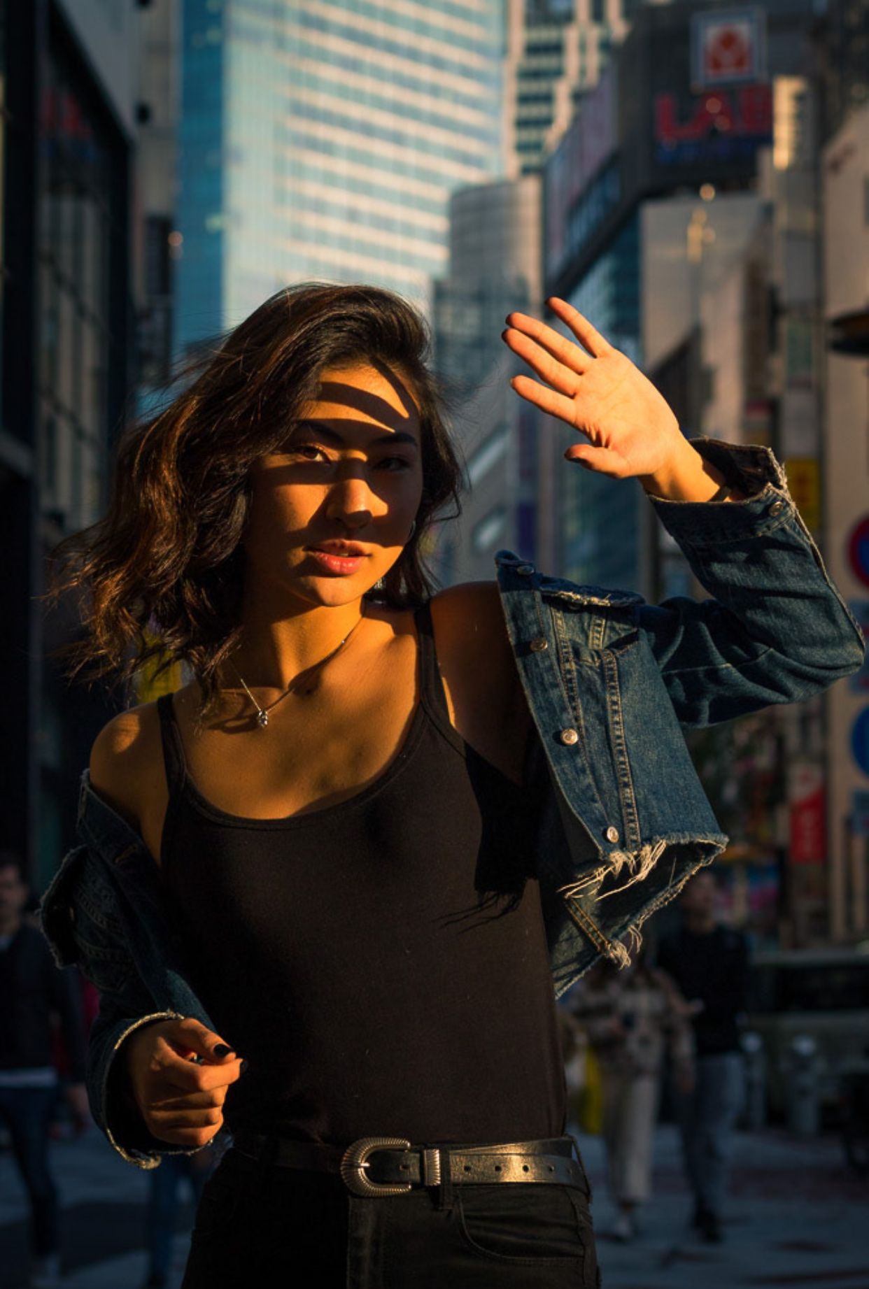 Urban street photography with dramatic shadows and sunlight in city setting.