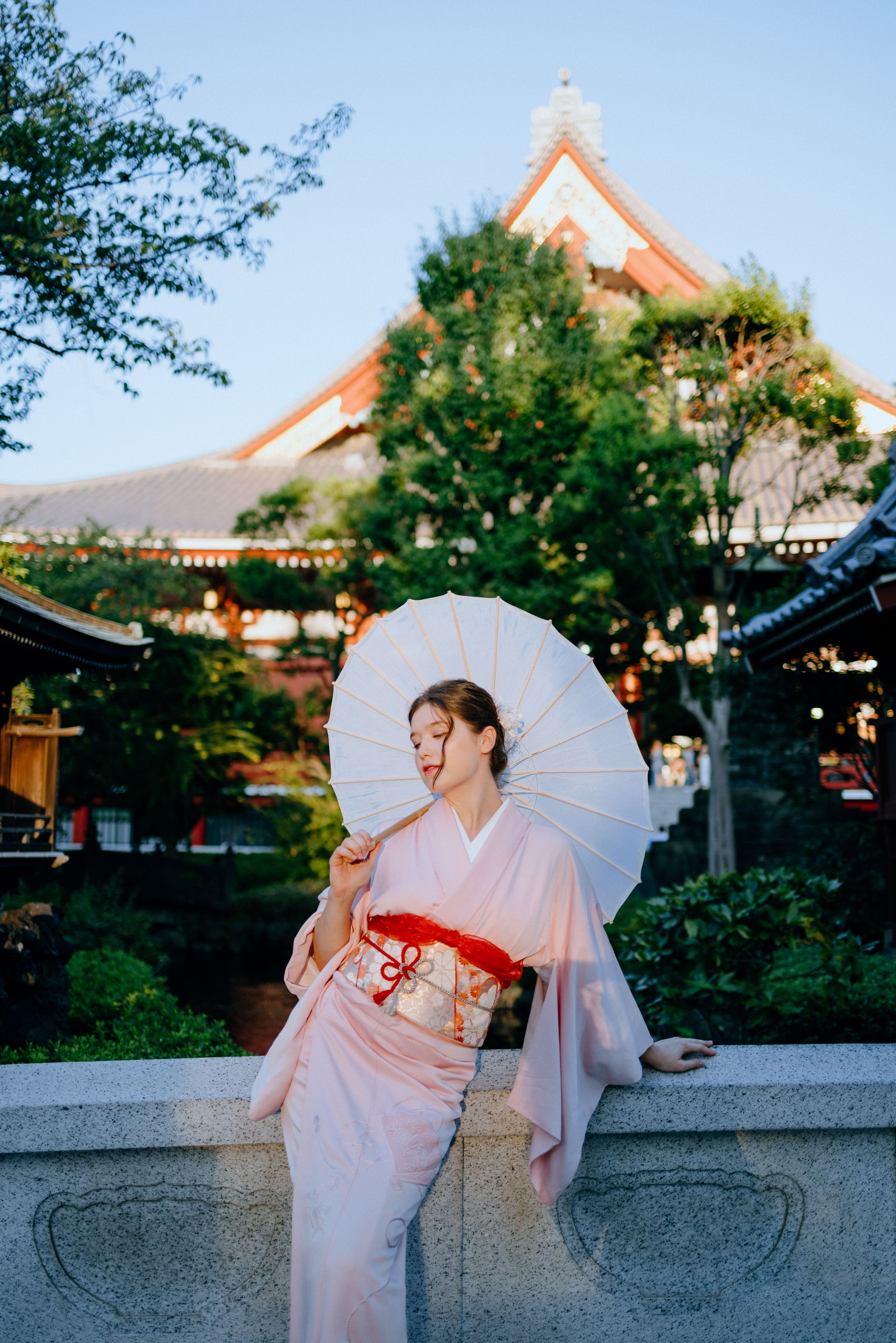Traditional Japanese garden scene with white parasol and pink kimono.