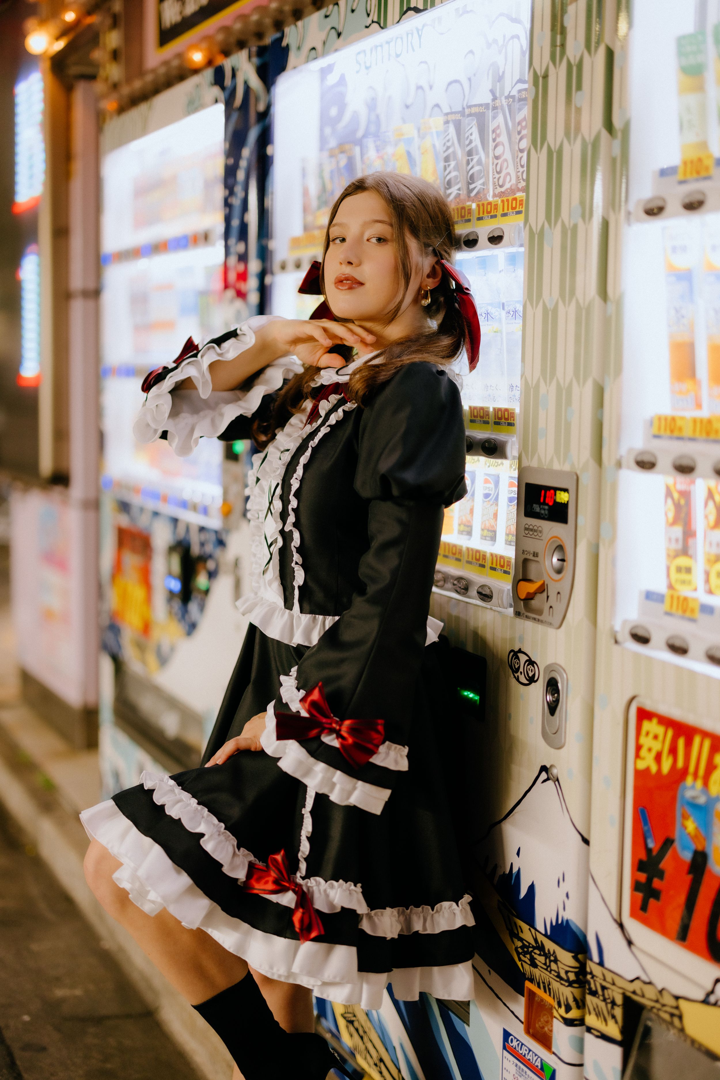 Gothic Lolita fashion displayed in front of Japanese vending machines.