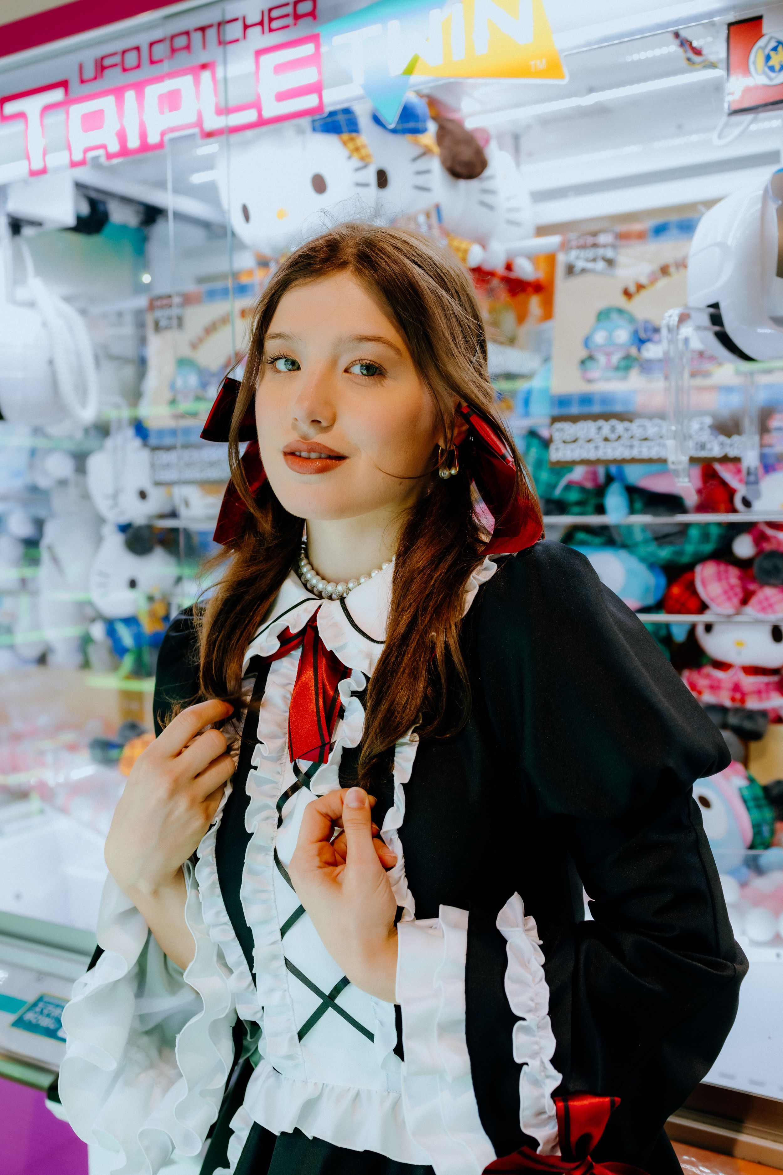 Classic Lolita fashion portrait in front of colorful Japanese arcade games.