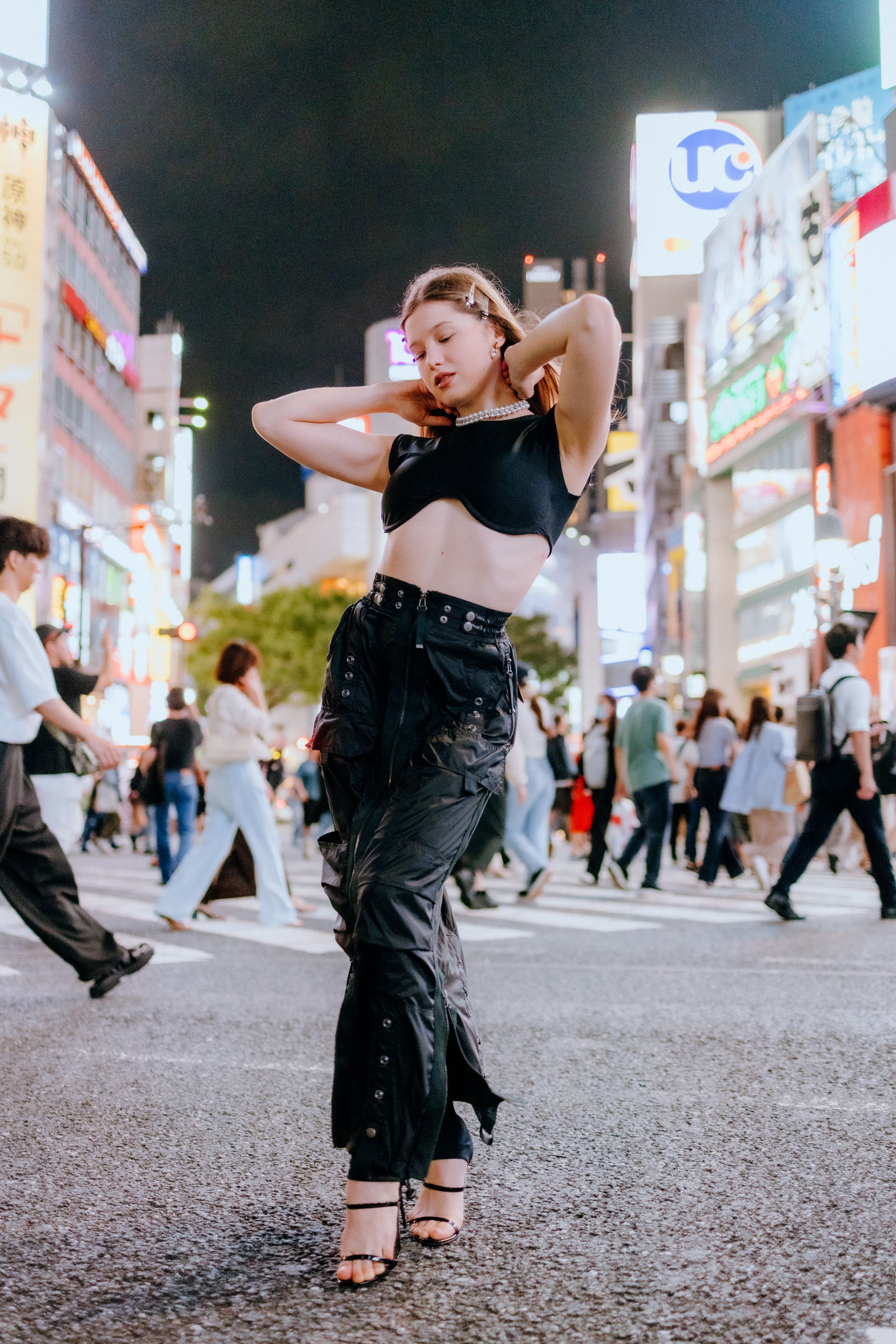 Street fashion photography on Shibuya crossing at night in Tokyo.