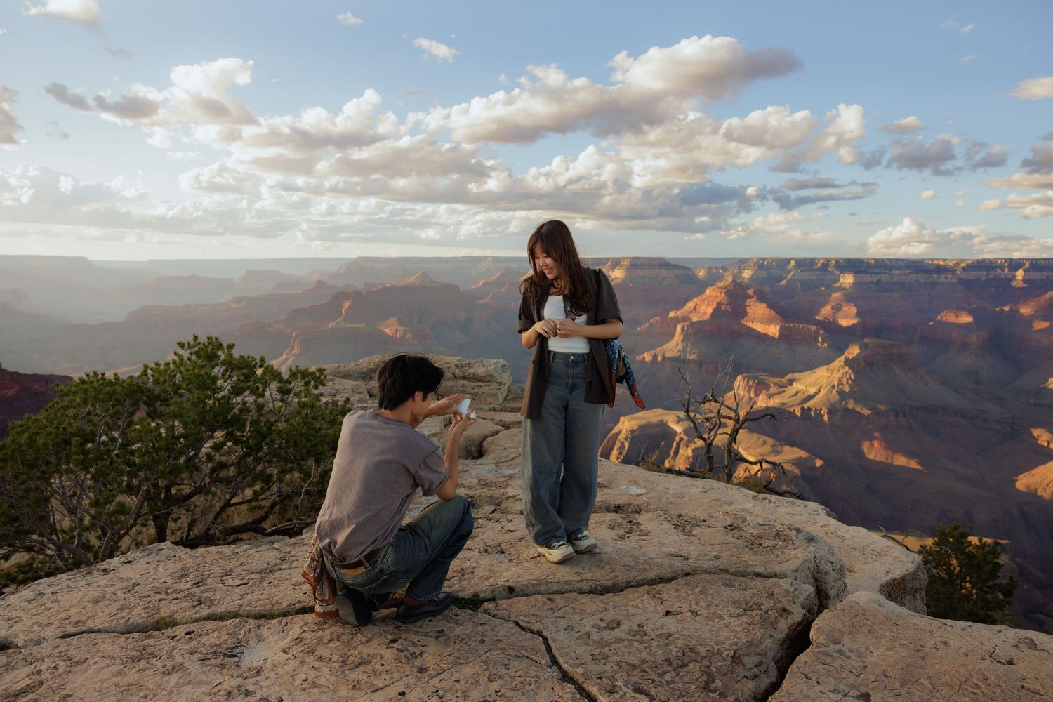 A young man proposes to a young woman at the Grand Canyon south rim.