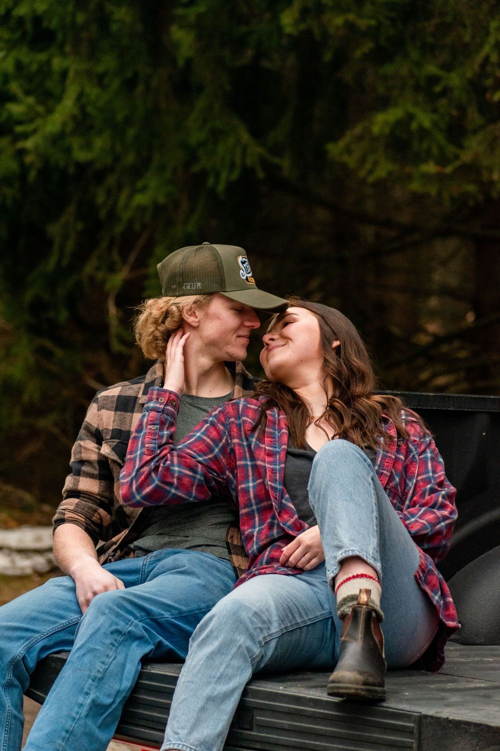 Two people share an intimate moment while sitting on a truck bed.