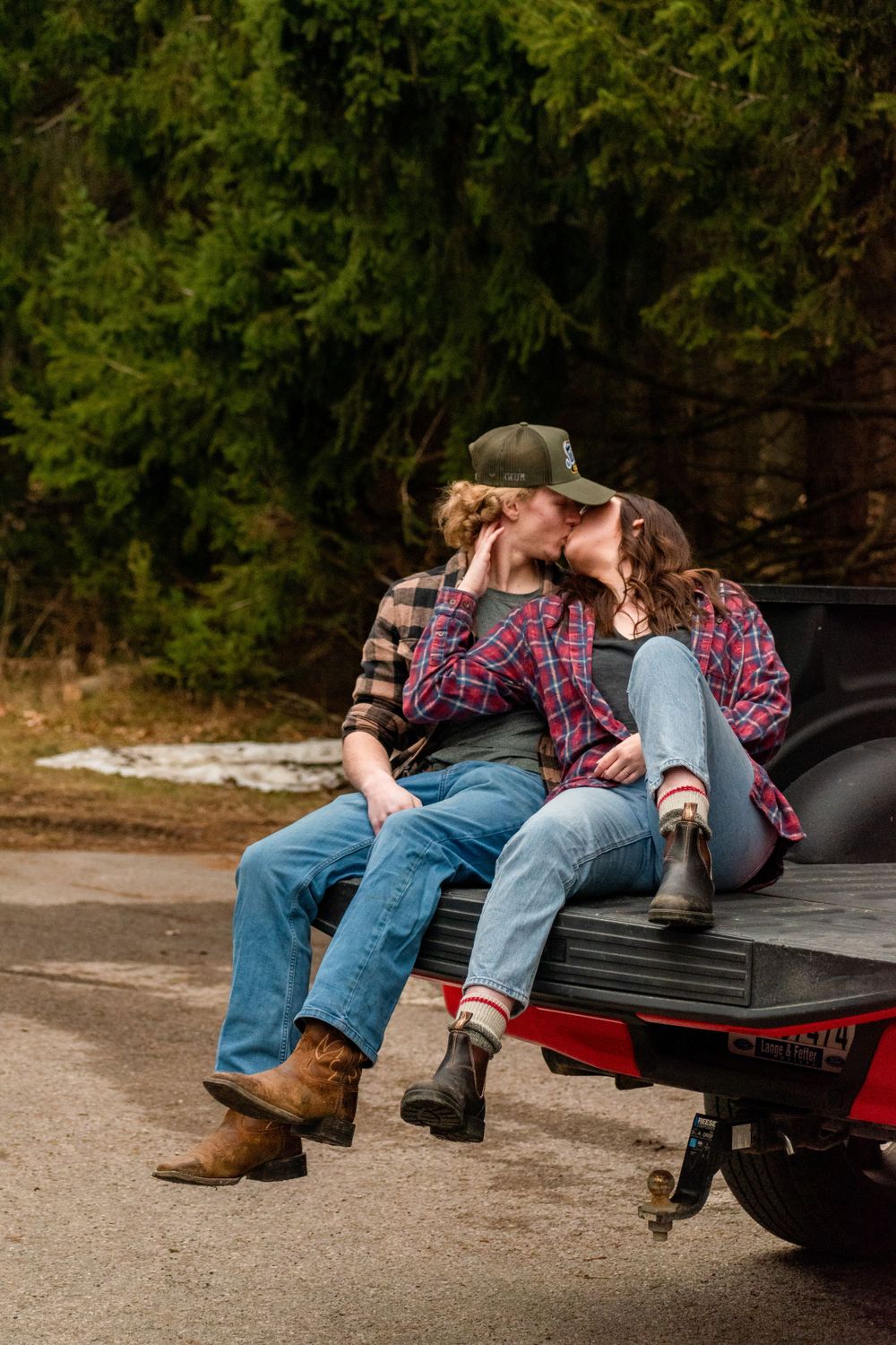 Couple sharing a romantic moment on the tailgate of a pickup truck.