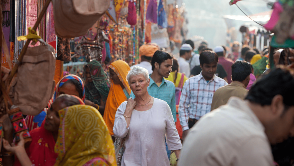 Bustling marketplace scene with colorful textiles and diverse crowd of shoppers.