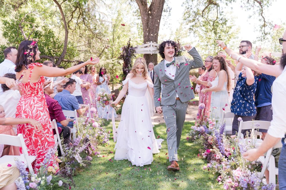 A candid shot of the bride and groom laughing joyfully at their wedding ceremony, surrounded by family and friends, radiating love