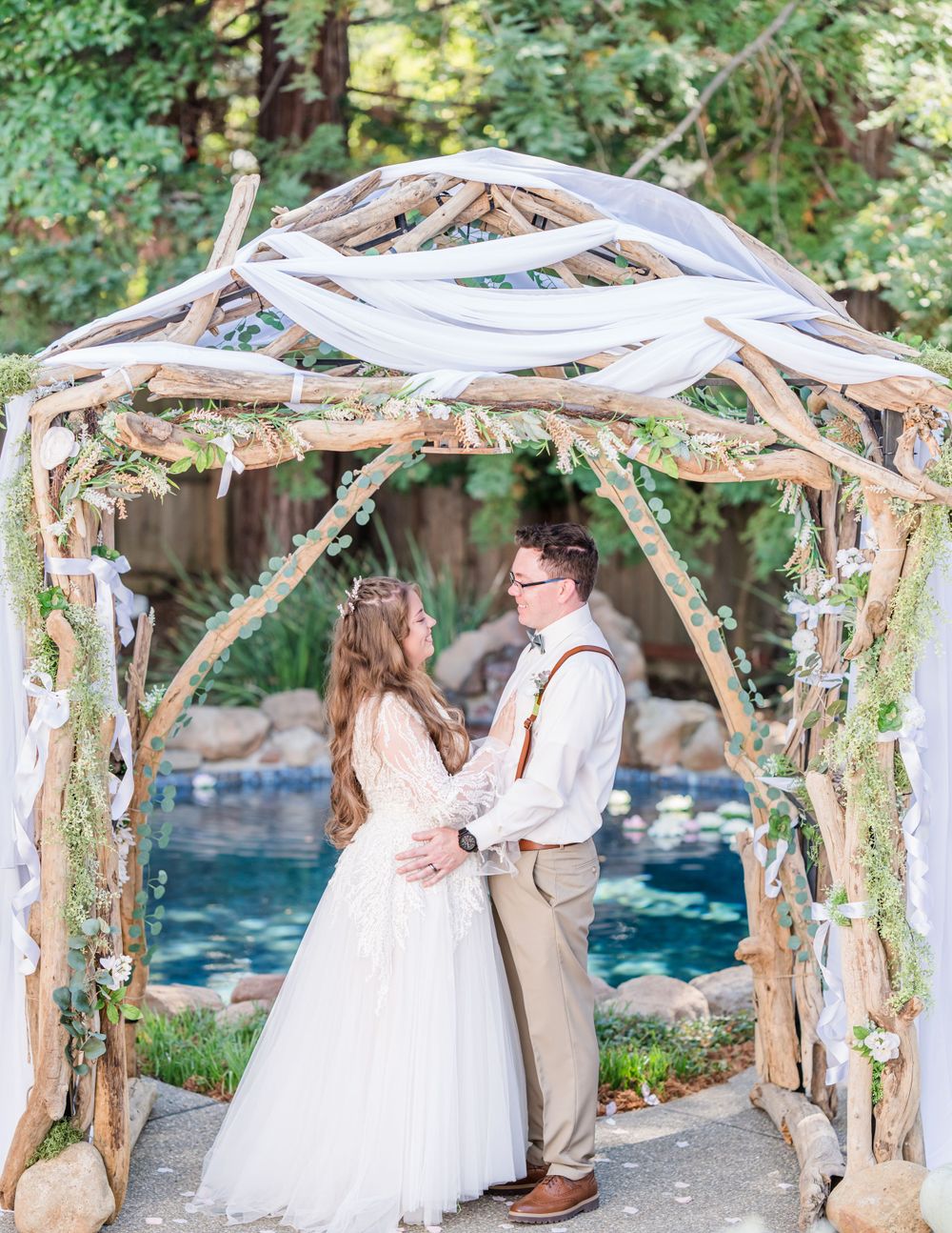 The bride and groom share a quiet moment in a lush garden, their love beautifully captured among the vibrant flowers and greenery