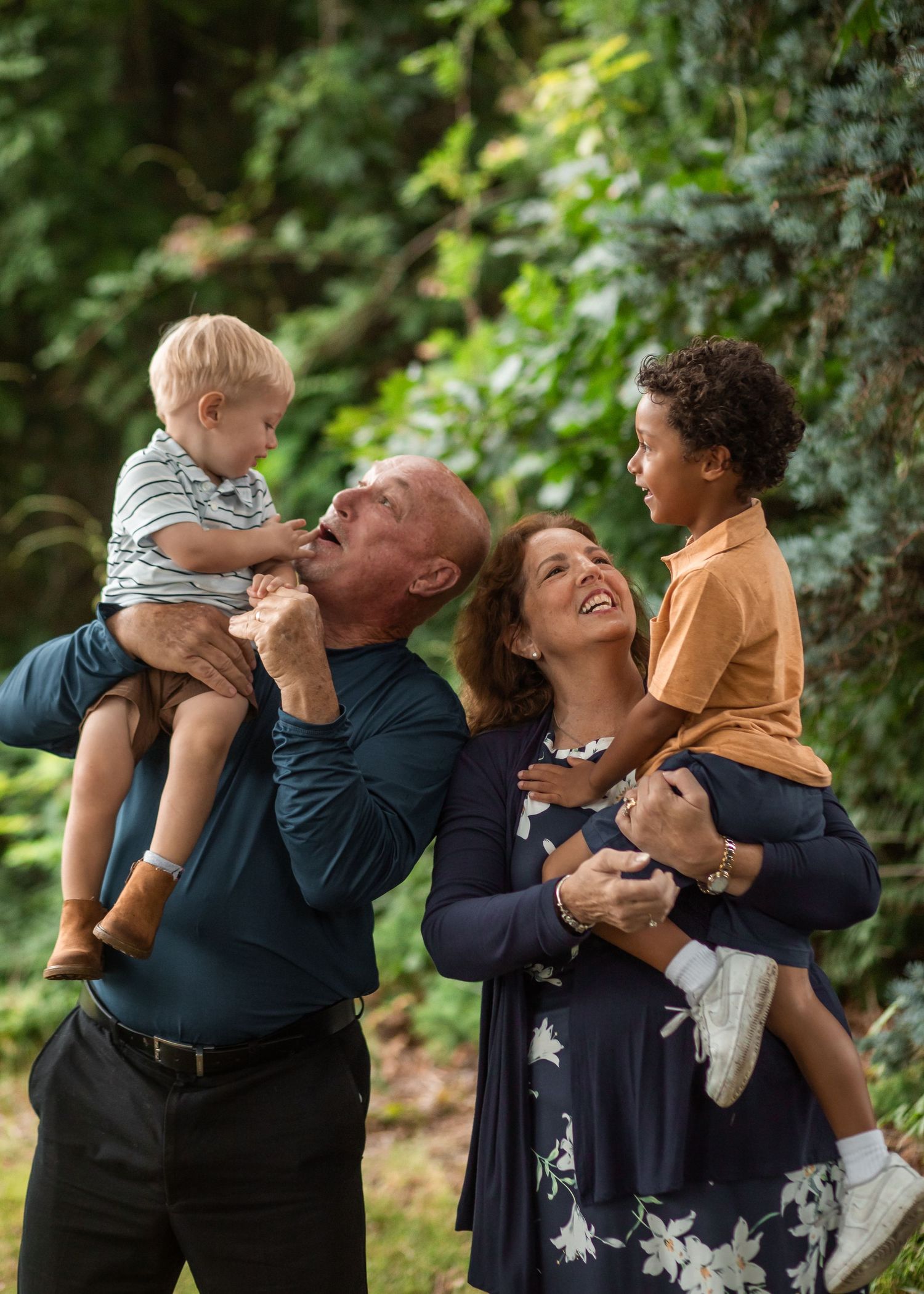 Grandparents share joyful moments together with their grandsons in a series against a green natural background in Boston, Massachusetts, USA