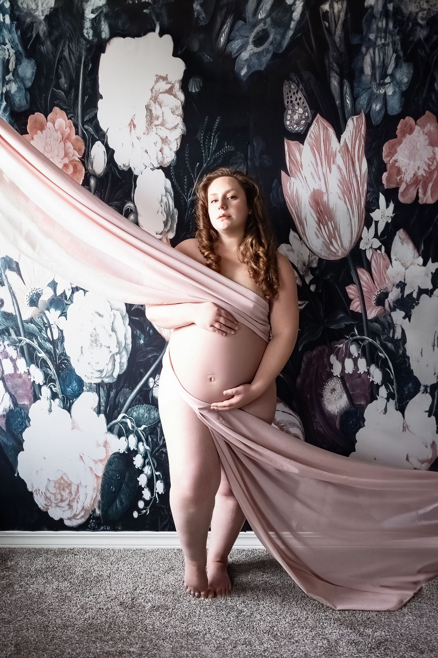 Maternity Boudoir Photo Shoot in Colorado Springs, pregnant woman in pink fabric pull in front of floral backdrop