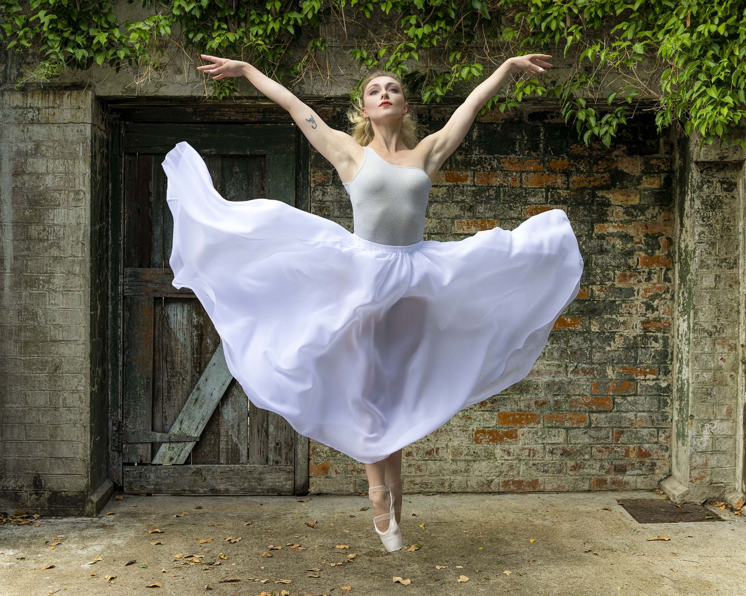 Woman dancer in white dress leaping. Image by Nick Wigmore Photography.