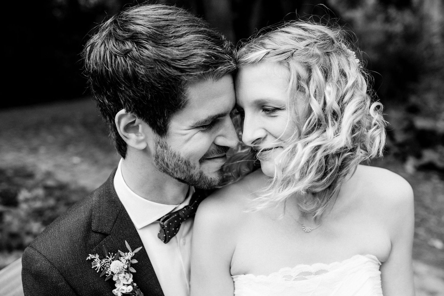 Black and white close-up portrait of couple sharing tender moment with natural lighting.