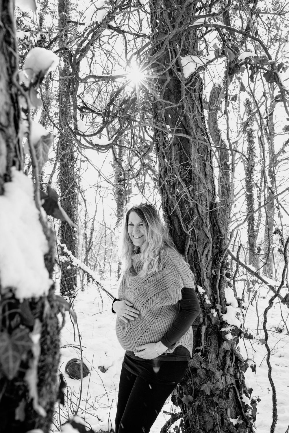 Black and white winter forest scenes with dramatic sunlight through snow-covered trees.