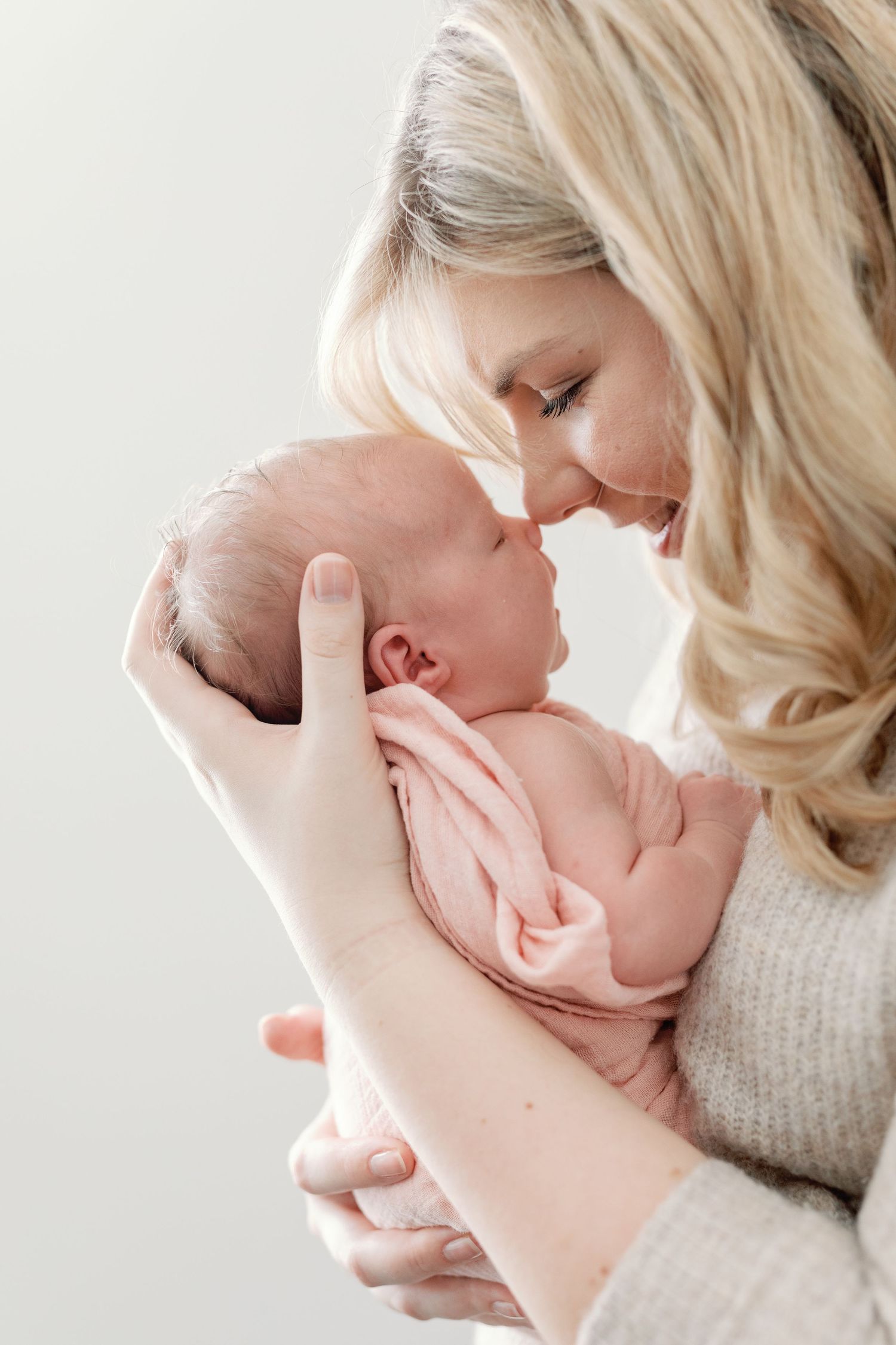 Gentle moments of affection between a caregiver and baby in natural light.