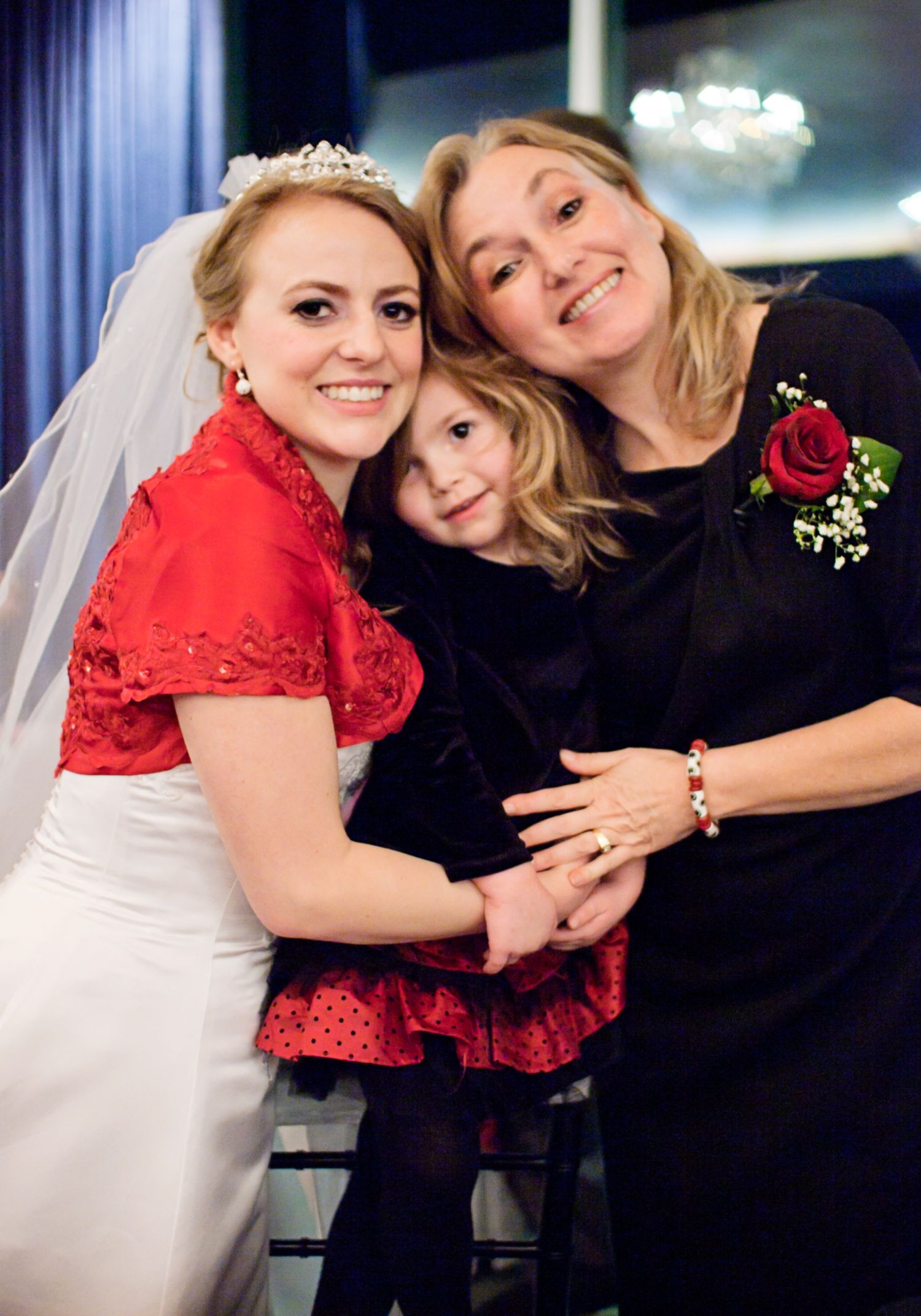 An emotional wedding moment captured with red and black attire against an elegant backdrop.