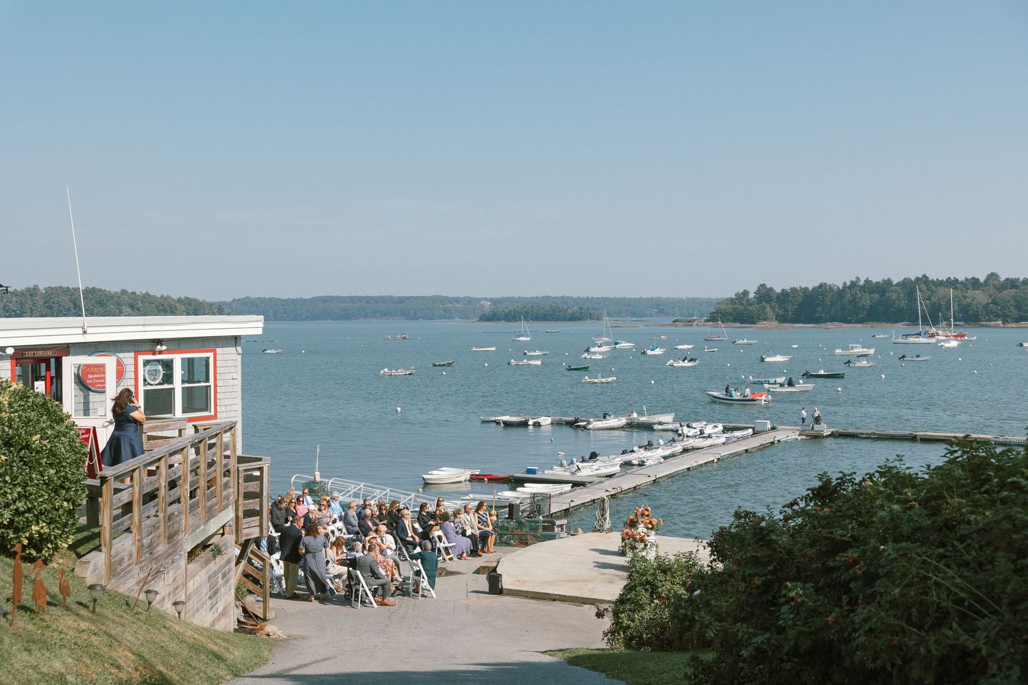 Panoramic view of a coastal marina with boats and docks on a sunny day.