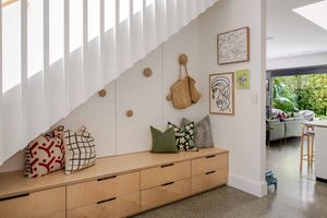 Modern white staircase with wooden steps and handrail leads upward in a minimalist interior design setting.