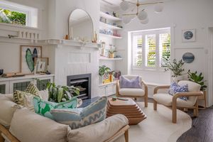 Bright and airy modern bedroom with white walls, natural light, and coastal-inspired decor featuring blue accents.