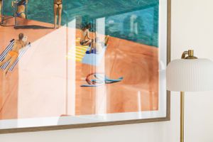 Framed swimming pool artwork with turquoise water and coral tones behind glass.