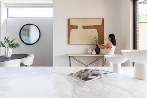 Modern interior with marble table and artwork, featuring minimalist decor elements.