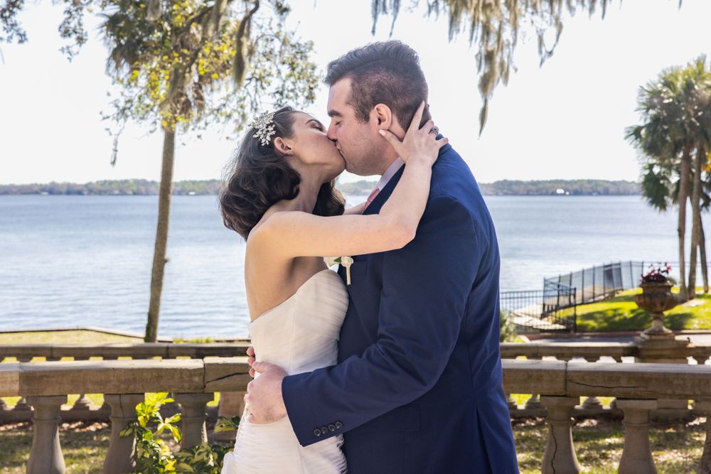 A couple sharing their first kiss during waterfront wedding ceremony.
