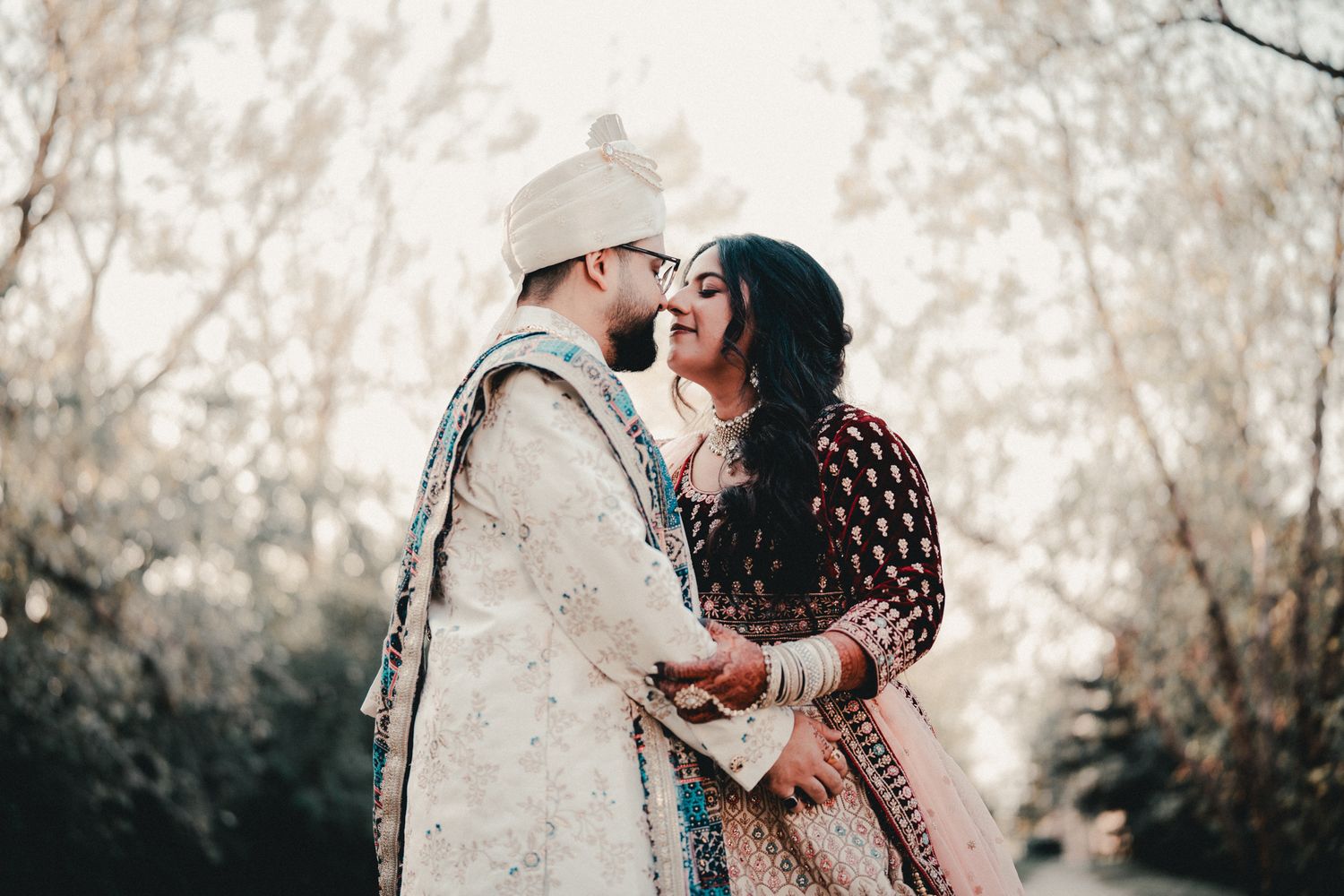 A romantic moment between a couple wearing ornate South Asian wedding outfits. Indian Wedding Photography Toronto GTA