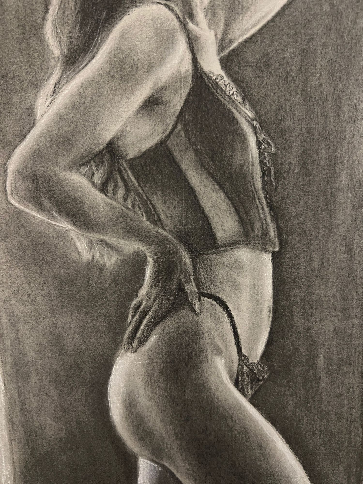 A charcoal drawing shows a person viewed from the side in a contemplative pose custom figure drawing boudoir