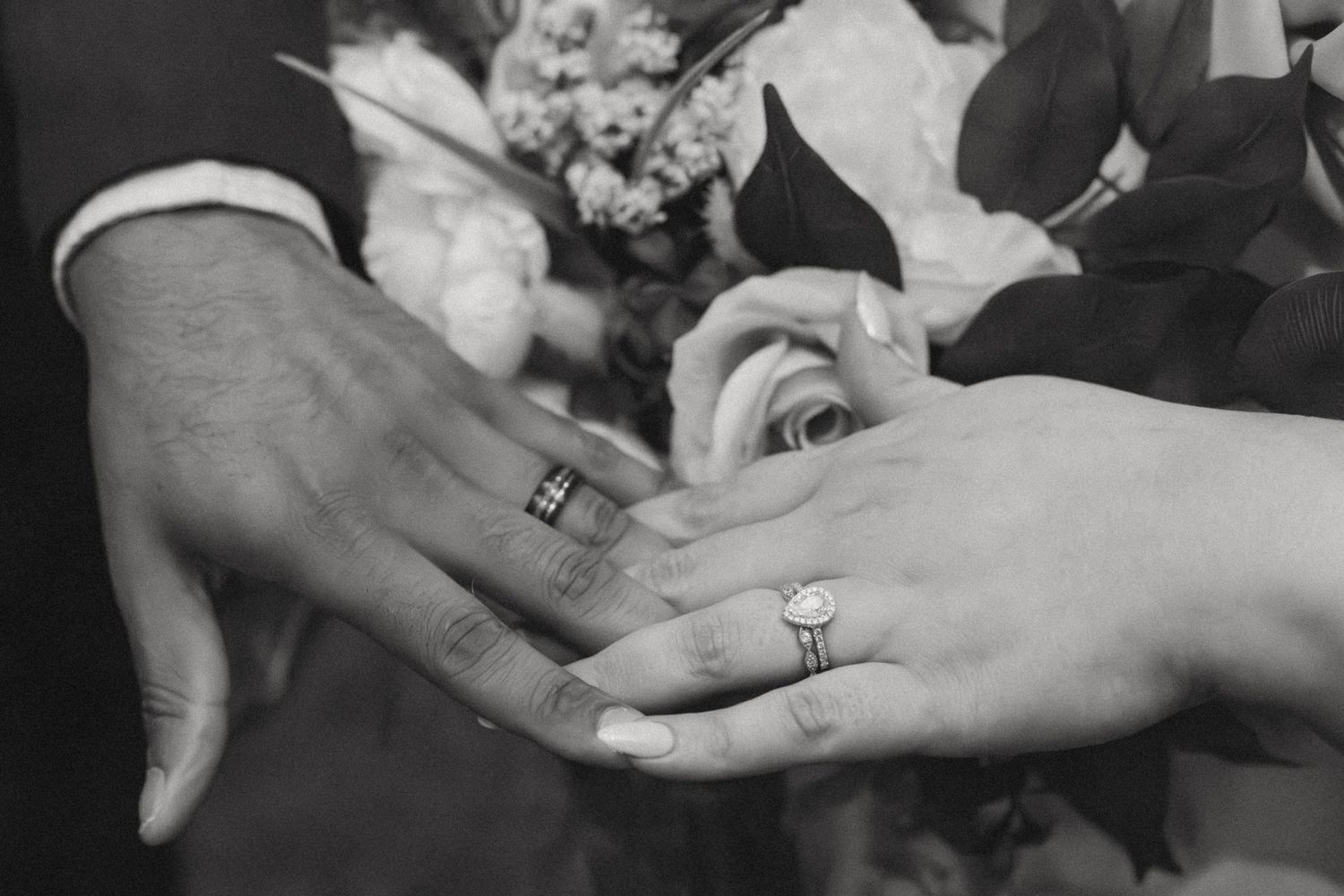 Newly married couple show of wedding rings in black & white