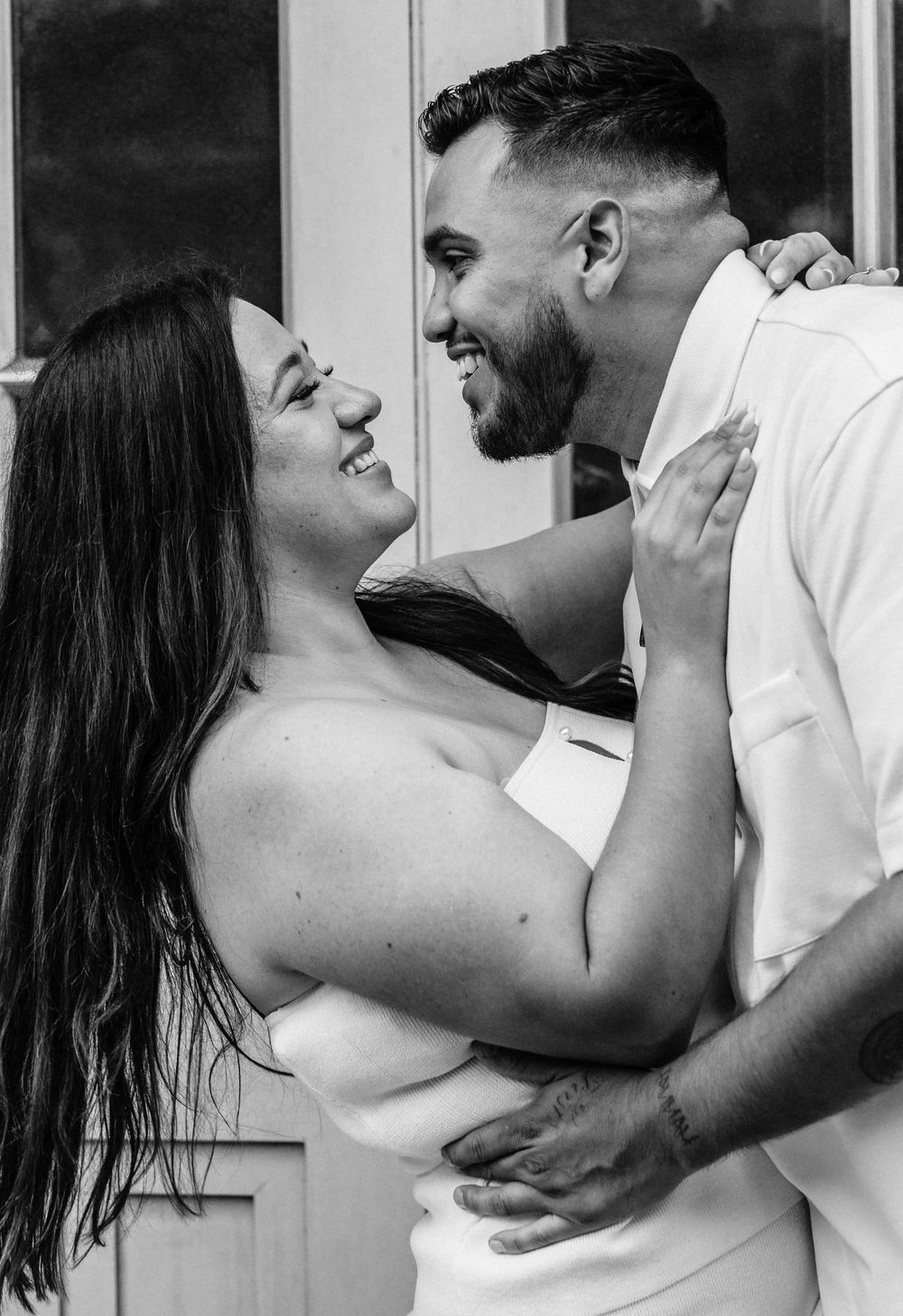 Black and white romantic portrait series of couple embracing and sharing intimate moments.