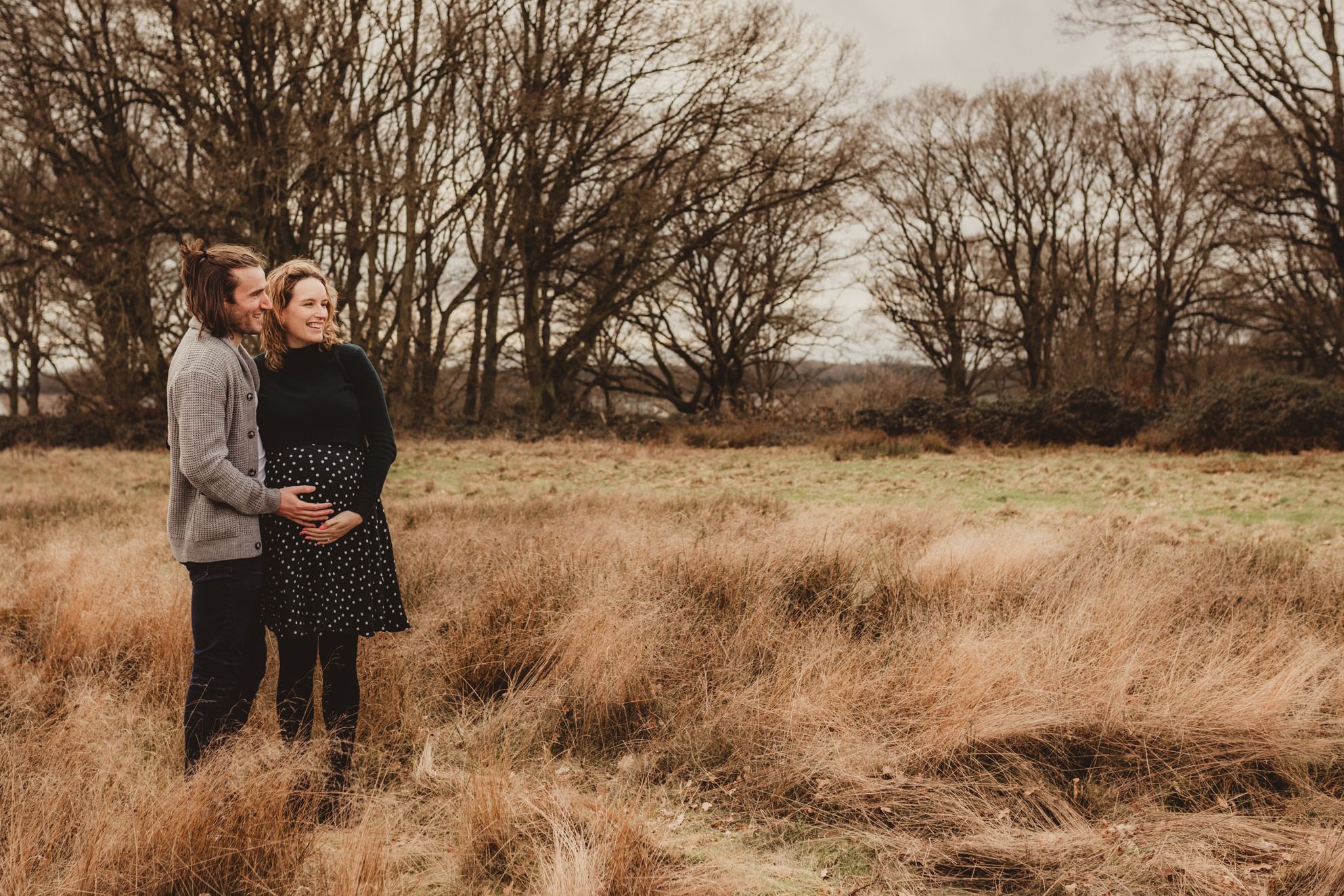 parent-to-be standing in a heath looking into the distance