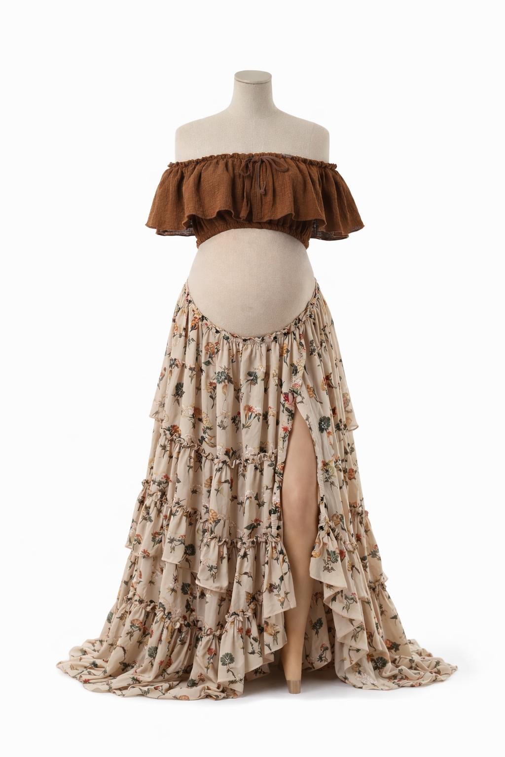 Maternity mannequin wearing brown off-shoulder ruffle crop top and floral tiered maxi skirt with front slit.