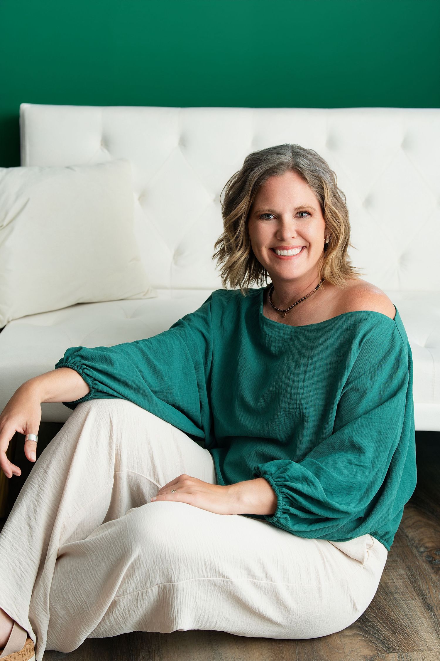 Lifestyle portraits on orange background with person posing on dark blue couch.