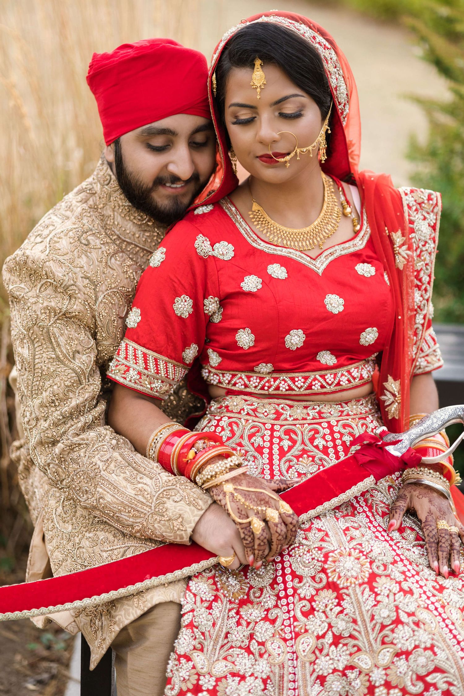 Joyful newly weds expressing intimate love captured by the photographers camera, Holding a red kirpan