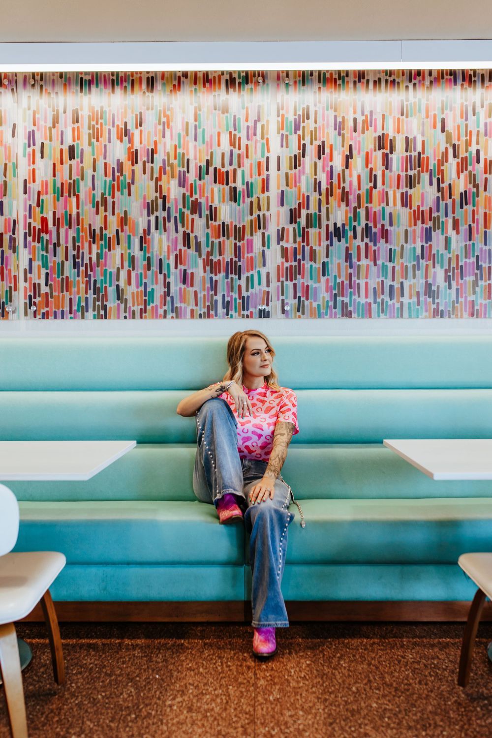 A retro diner interior featuring a mint green booth seat with colorful vertical stripes decorating the wall behind.
