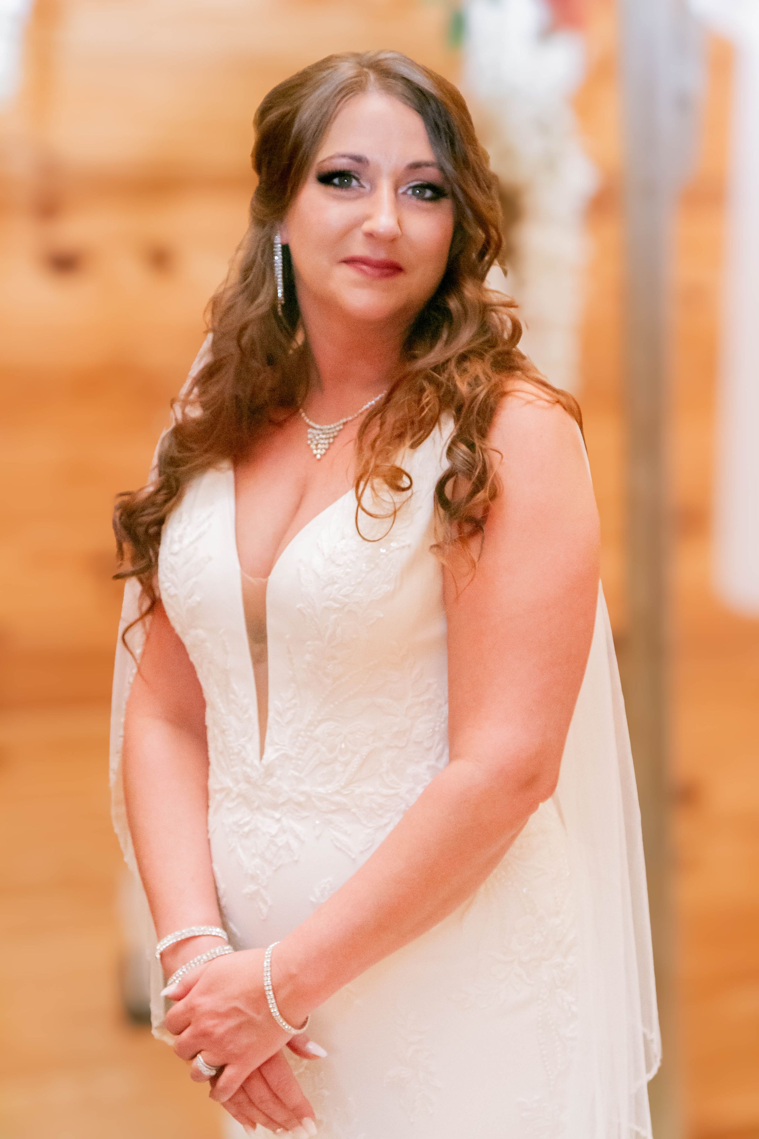 A bride in a plunging V-neck wedding dress poses for a formal portrait.