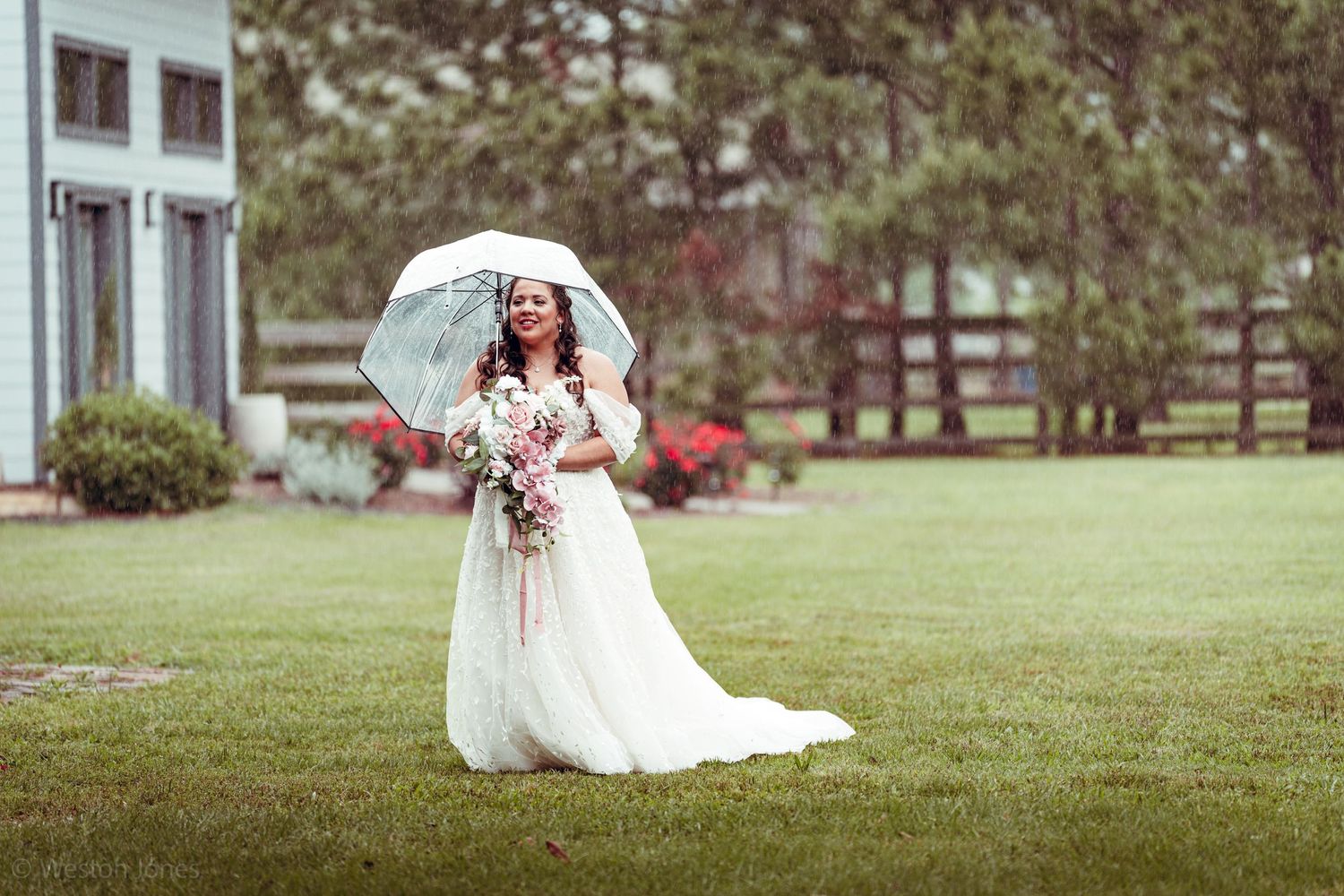 A bridal portrait on a lush lawn with a white parasol and flowing gown.