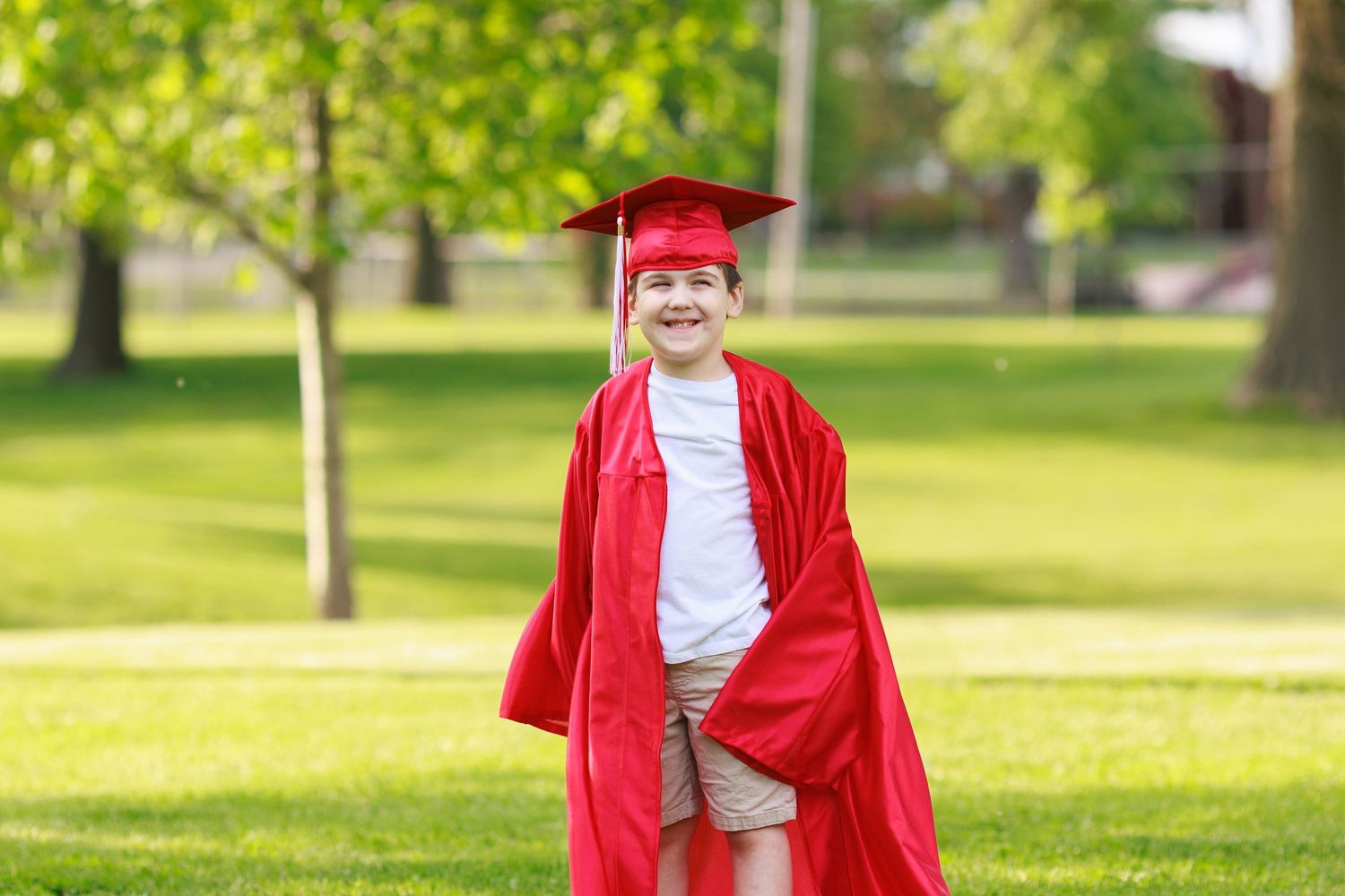 proud kinder grad wearing his cap and gown