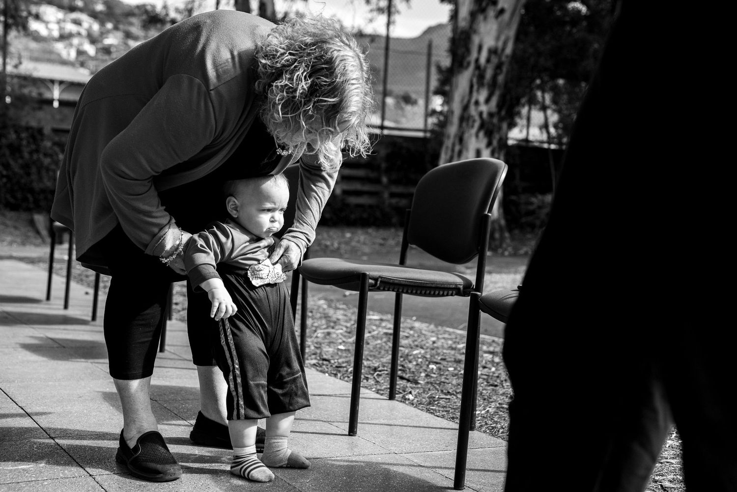 A tender black and white moment captured between two figures in an outdoor setting.