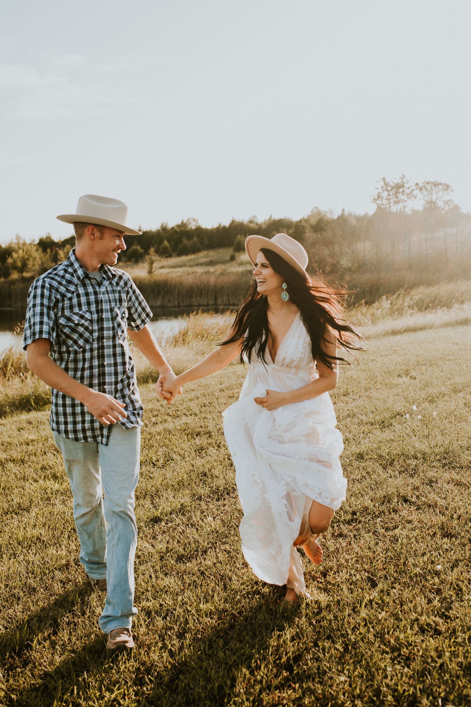 Couple dances playfully in a sunlit field during golden hour photo session. Oklahoma Wedding Photographer