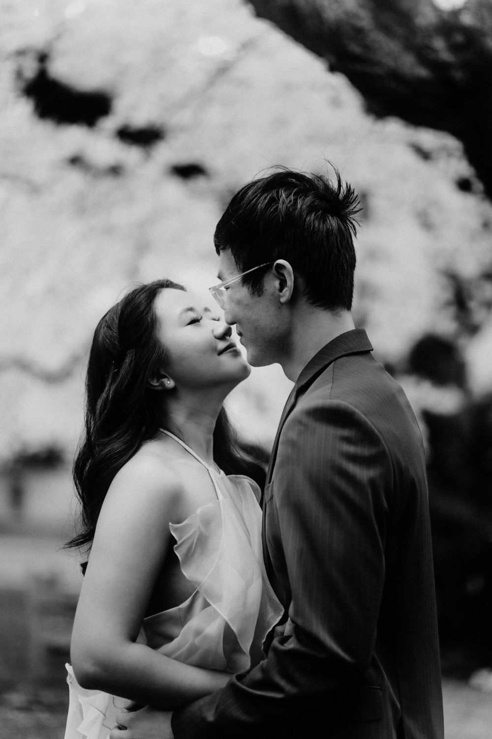 Black and white street photography of a couple touching noses in Seattle's UW Quad