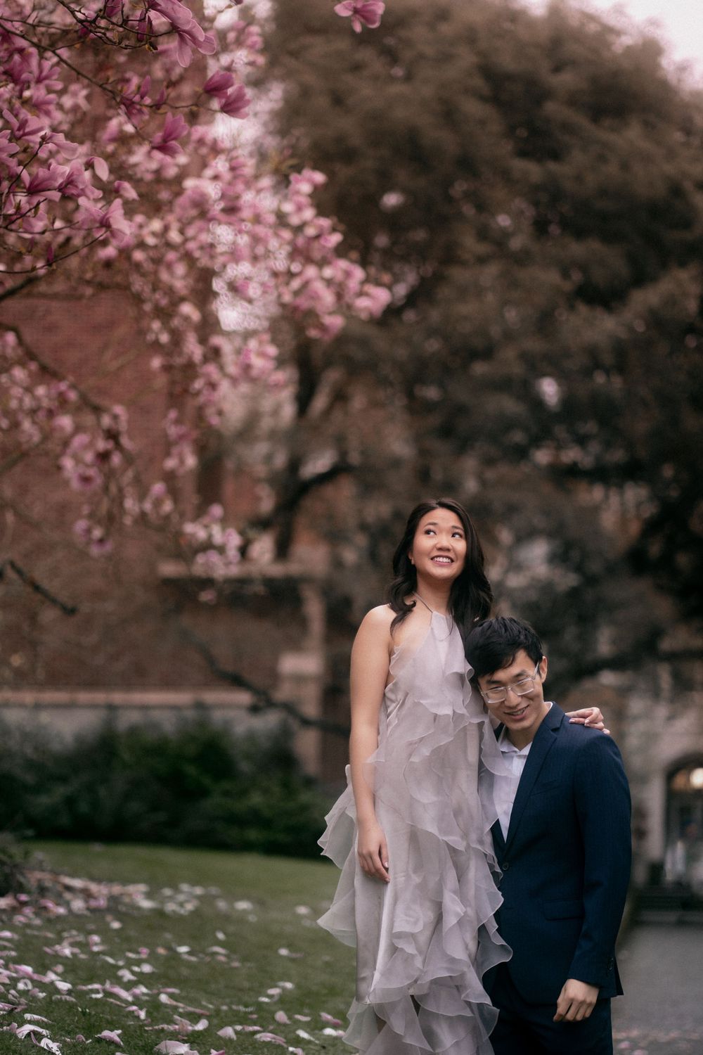 A couple standing by blooming magnolia tree in Seattle's UW Quad
