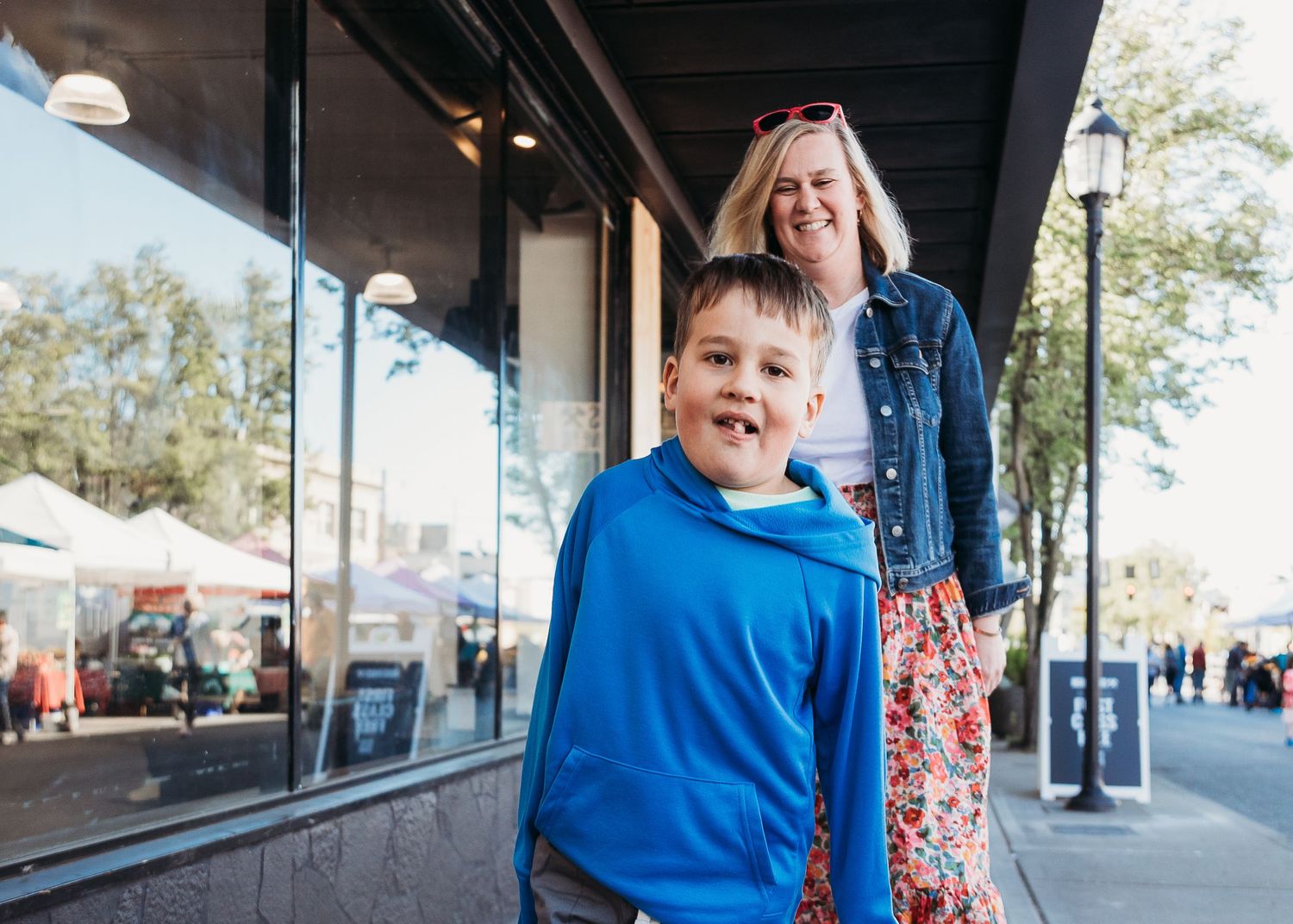 Casual street scene outside storefronts with two people in bright casual wear.