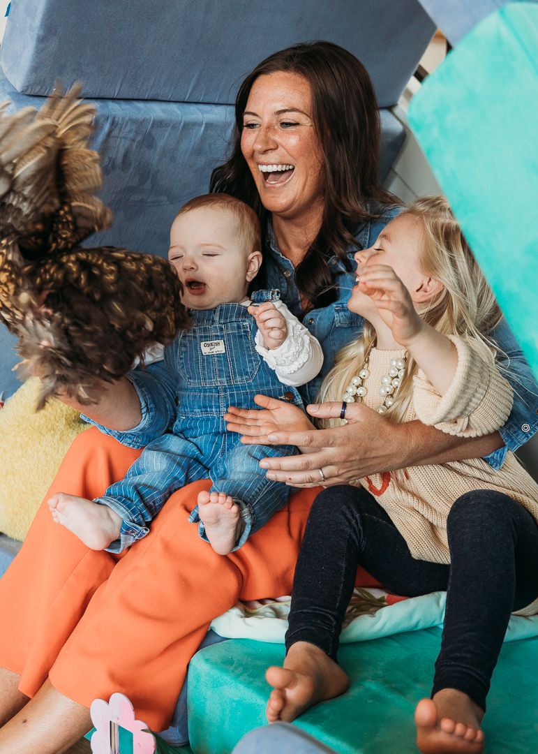 Happy group sharing laughs and playtime on colorful floor cushions.