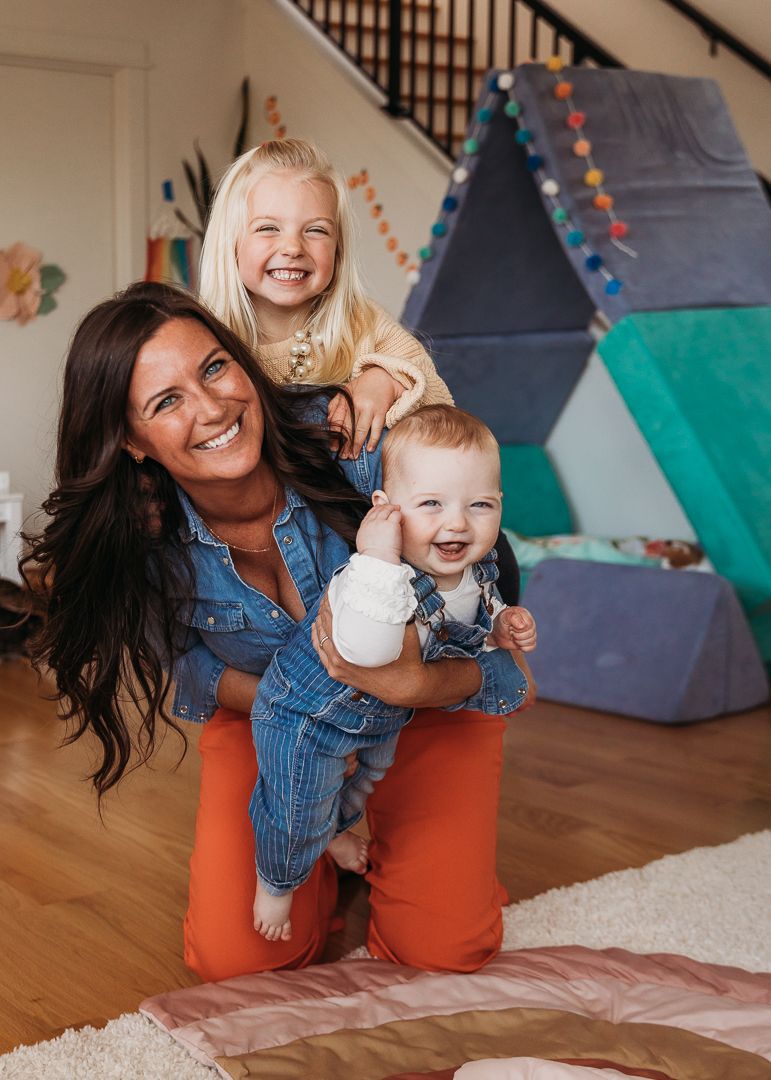 Playful indoor moment with a tent fort decoration in the background.