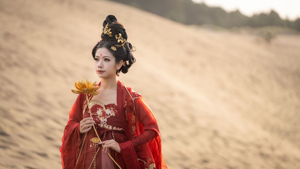 Cinematic solo portrait in flowing red Hanfu at Lake Wainamu sand dunes, evoking a fateful Desert Princess vibe, by Imagine Image Studio.